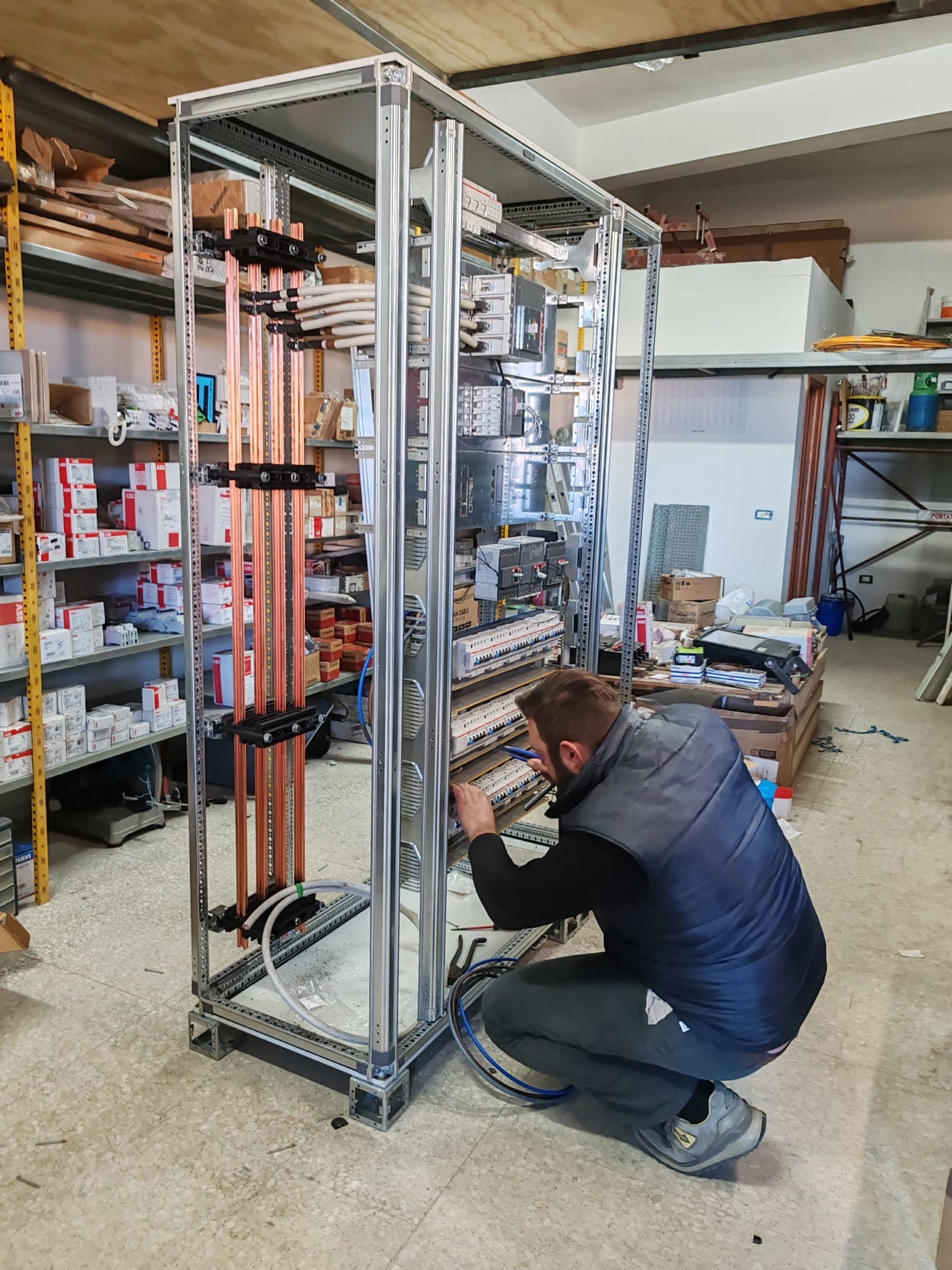 elettricista al lavoro su quadro elettrico per interventi a Momena